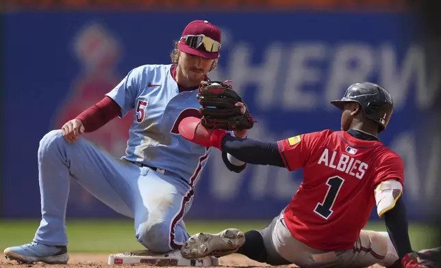 Atlanta Braves' Ozzie Albies, right, is tagged out by Philadelphia Phillies second baseman Bryson Stott after trying to steal second during the ninth inning in the first baseball game of a doubleheader Thursday, May 29, 2025, in Philadelphia. (AP Photo/Matt Slocum)