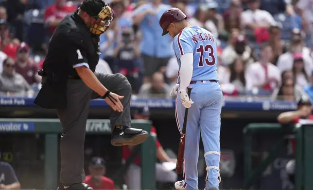 Philadelphia Phillies' Rafael Marchán, right, and umpire Bruce Dreckman react after Marchán was hit by a pitch from Atlanta Braves' Daysbel Hernández with the bases loaded during the eighth inning in the first baseball game of a doubleheader Thursday, May 29, 2025, in Philadelphia. (AP Photo/Matt Slocum)