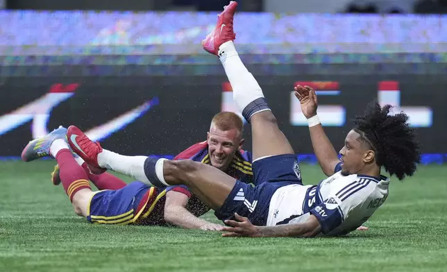 Vancouver Whitecaps' Jayden Nelson, right, falls after being shoved off the ball by Real Salt Lake's Justen Glad, left, during the second half of an MLS soccer match in Vancouver, British Columbia, Saturday, May 3, 2025. (Darryl Dyck/The Canadian Press via AP)