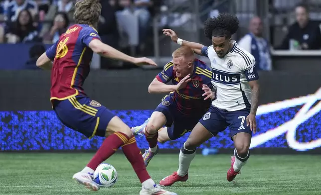 Vancouver Whitecaps' Jayden Nelson, back right, is shoved off the ball by Real Salt Lake's Justen Glad, back left, as Philip Quinton, front left, watches during the second half of an MLS soccer match, in Vancouver, on Saturday, May 3, 2025. (Darryl Dyck/The Canadian Press via AP)