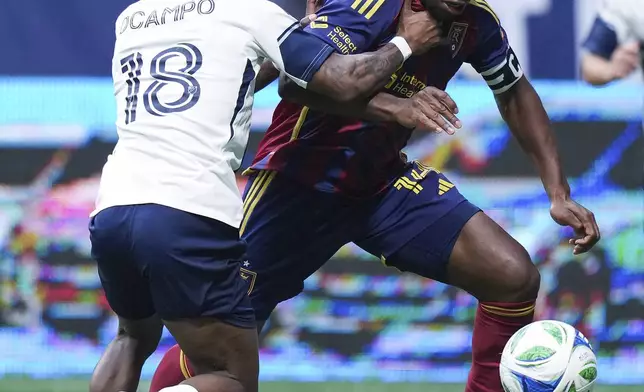 Real Salt Lake's Emeka Eneli, right, and Vancouver Whitecaps' Edier Ocampo vie for the ball during the first half of an MLS soccer match, in Vancouver, on Saturday, May 3, 2025. (Darryl Dyck/The Canadian Press via AP)