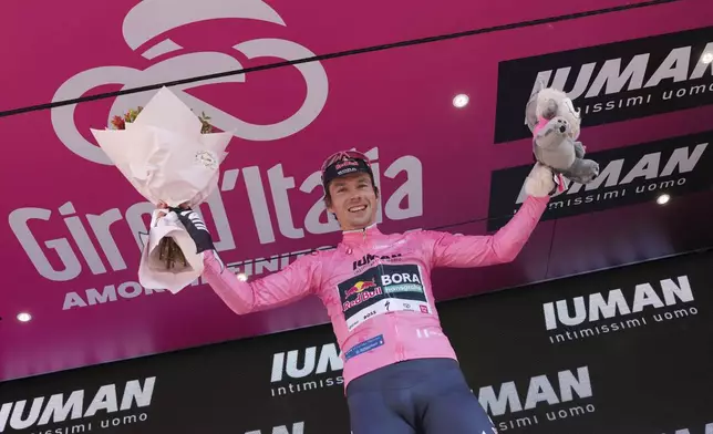 Slovenia's Primoz Roglic celebrates on the podium after earning the pink jersey of overall leader after the time trial stage 2 of the Giro d'Italia cycling race, in Tirana, Albania, Saturday, May 10, 2025. (Gian Mattia D'Alberto/LaPresse via AP)