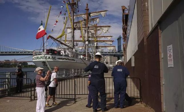 United States Coast Guardsmen arrive at Pier 35, Sunday, May 18, 2025 in New York, where the Cuauhtémoc, a masted Mexican Navy training ship that collided with the Brooklyn Bridge the night before, sits docked. (AP Photo/Yuki Iwamura)