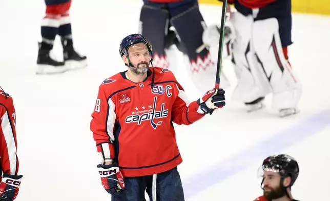 Washington Capitals left wing Alex Ovechkin (8) raises his stick to the crowd after Game 5 of a second-round NHL hockey playoff series against the Carolina HurricanesThursday, May 15, 2025, in Washington. (AP Photo/Nick Wass)