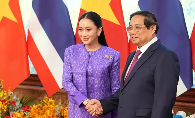 Vietnamese Prime Minister Pham Minh Chinh, right, and Thai Prime Minister Paetongtarn Shinawatra shake hands in Hanoi, Vietnam Friday, May 16, 2025. (AP Photo/Hau Dinh)