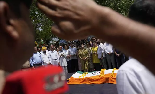Police personnel pay tribute to Raj Thapa, a senior bureaucrat who was killed in Pakistani shelling in Rajouri, at his funeral in Jammu, India, Sunday, May 11, 2025. (AP Photo/Channi Anand)