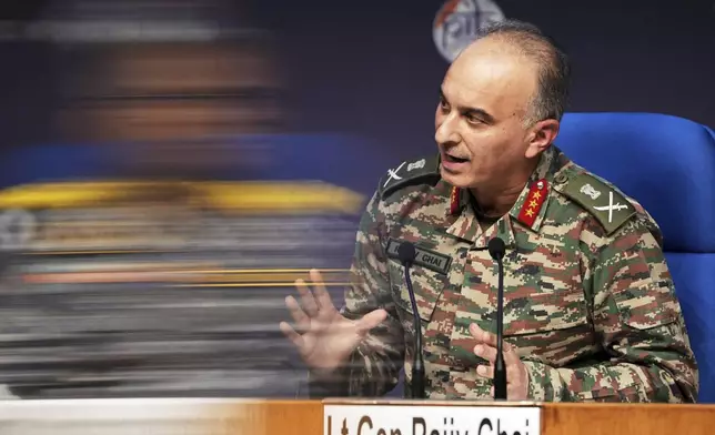 Director General of Military Operations Lt. Gen. Rajiv Ghai speaks during a press conference as a blurred reflection of Vice Admiral AN Pramod is seen on a glass pane, in New Delhi, Sunday, May 11, 2025. (AP Photo/Karma Bhutia)