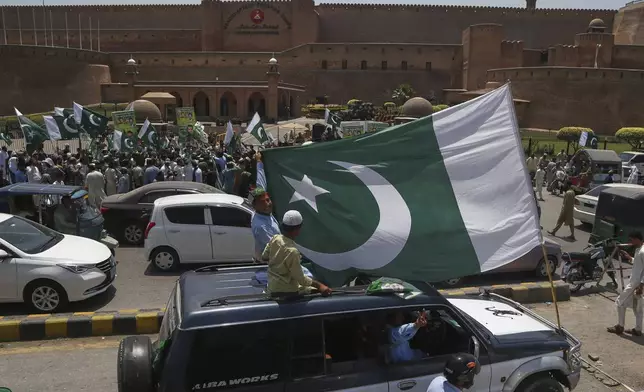 People with national flags take part in a demonstration to show their support with Pakistan Army, a day after the ceasefire between Indian and Pakistan was announced, in Peshawar, Pakistan, Sunday, May 11, 2025. (AP Photo/Muhammad Sajjad)