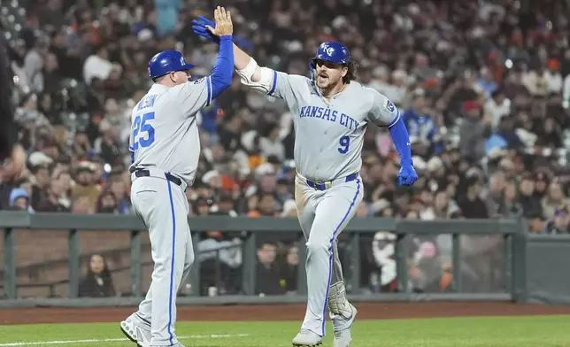 Kansas City Royals' Vinnie Pasquantino (9) is congratulated by third base coach Vance Wilson after hitting a two-run home run against the San Francisco Giants during the eighth inning of a baseball game in San Francisco, Monday, May 19, 2025. (AP Photo/Jeff Chiu)