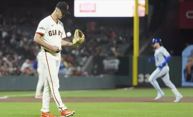 San Francisco Giants pitcher Tyler Rogers, left, reacts after giving up a two-run home run to Kansas City Royals' Vinnie Pasquantino, right, during the eighth inning of a baseball game in San Francisco, Monday, May 19, 2025. (AP Photo/Jeff Chiu)