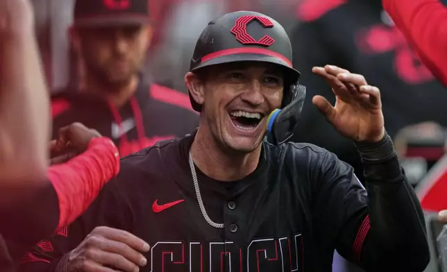 Cincinnati Reds Austin Hays celebrates in the dugout after scoring on a wild pitch from Chicago Cubs pitcher Matthew Boyd in the third inning of a baseball game, Friday, May 23, 2025, in Cincinnati. (AP Photo/Carolyn Kaster)