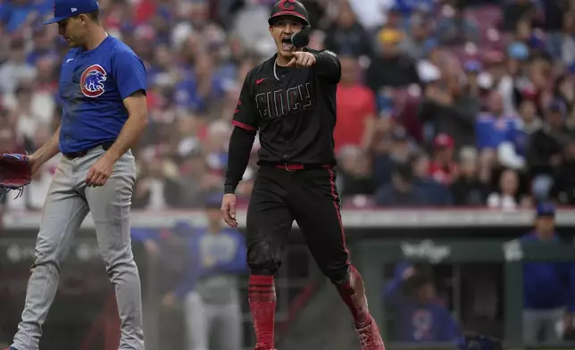 Cincinnati Reds' Austin Hays, right, reacts after scoring on a wild pitch from Chicago Cubs pitcher Matthew Boyd, left, in the third inning of a baseball game, Friday, May 23, 2025, in Cincinnati. (AP Photo/Carolyn Kaster)