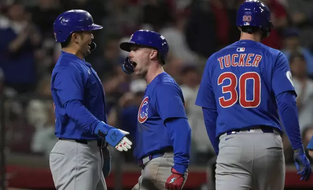 Chicago Cubs' Pete Crow-Armstrong, center, celebrates with Seiya Suzuki, left, and outfielder Kyle Tucker, right, after hitting a grand slam to right field during the seventh inning of a baseball game against the Cincinnati Reds, Friday, May 23, 2025, in Cincinnati. (AP Photo/Carolyn Kaster)