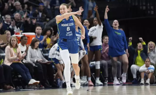 Minnesota Lynx forward Alanna Smith (8) points after making a three-point shot during the second half of a WNBA basketball game against the Seattle Storm, Tuesday, May 27, 2025, in Minneapolis. (AP Photo/Abbie Parr)