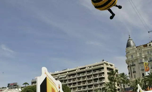 FILE - American comedian Jerry Seinfeld, dressed as a bee, glides through the air connected to a wire during a publicity stunt for the film "Bee Movie," at the 60th International film festival in Cannes, southern France, on Thursday, May 17, 2007. (AP Photo/Andrew Medichini, File)