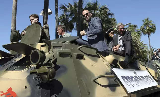 FILE - Dolph Lundgren, from second left, Jason Statham, and Harrison Ford ride atop an armored vehicle during a photo call for The Expendables 3 at the 67th international film festival, Cannes, southern France, Sunday, May 18, 2014. (Photo by Joel Ryan/Invision/AP, File)