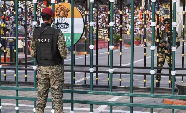 Pakistan's paramilitary soldier, left, and Indian Border Security Forces soldier, right, stand guard on their sides, during a daily closing ceremony at the Wagah, a joint post on the Pakistan and India border, near Lahore, Pakistan, Saturday, May 3, 2025. (AP Photo/K.M. Chaudary)
