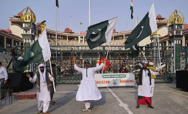 Pakistan's folk dancers perform with national flag during a daily closing ceremony at the Wagah, a joint post on the Pakistan and India border, near Lahore, Pakistan, Saturday, May 3, 2025. (AP Photo/K.M. Chaudary)