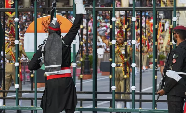 Pakistan's Rangers soldier, in black, and Indian Border Security Forces soldier, gesture to each other during a daily closing ceremony at the Wagah, a joint post on the Pakistan and India border, near Lahore, Pakistan, Saturday, May 3, 2025. (AP Photo/K.M. Chaudary)