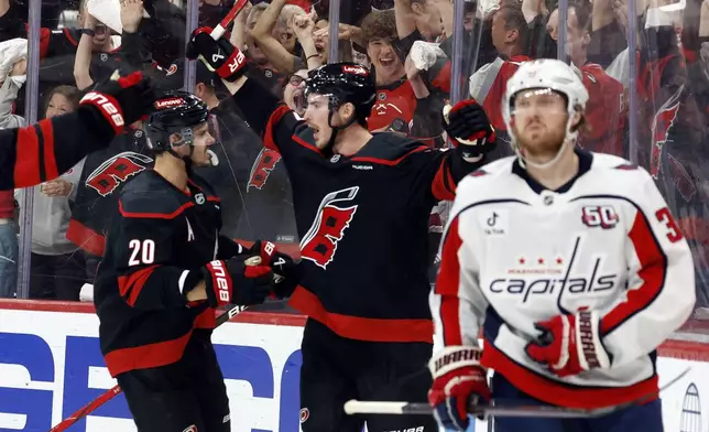 Carolina Hurricanes' Andrei Svechnikov, center, celebrates his goal with Sebastian Aho (20) during the second period of Game 3 of an NHL hockey Semi-final round playoff series against the Washington Capitals in Raleigh, N.C., Saturday, May 10, 2025. (AP Photo/Karl DeBlaker)