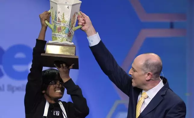 E.W. Scripps Company president and CEO Adam Symson presents the trophy to Faizan Zaki, 13, of Dallas, the winner of the 2025 Scripps National Spelling Bee, Thursday, May 29, 2025, in Oxon Hill, Md. (AP Photo/Julia Demaree Nikhinson)
