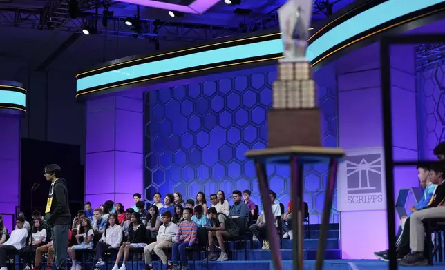 With the trophy in the foreground, Faizan Zaki, 13, of Dallas, competes in the finals of the Scripps National Spelling Bee, Thursday, May 29, 2025, in Oxon Hill, Md. (AP Photo/Julia Demaree Nikhinson)