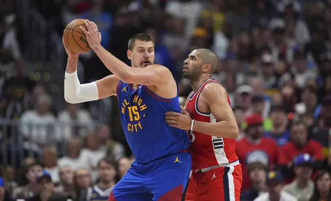 Denver Nuggets center Nikola Jokic, left, looks to pass the ball as Los Angeles Clippers forward Nicolas Batum, right, defends in the second half of Game 7 of an NBA basketball first-round playoff series Saturday, May 3, 2025, in Denver. (AP Photo/David Zalubowski)