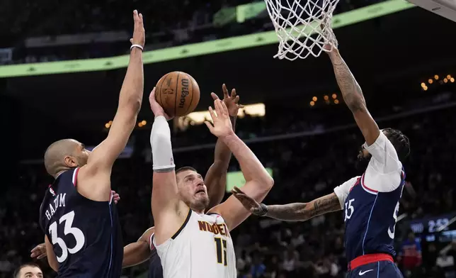 Denver Nuggets center Nikola Jokic, center, shoots as Los Angeles Clippers forward Nicolas Batum, left, and forward Derrick Jones Jr. defend during the second half in Game 6 of an NBA basketball first-round playoff series Thursday, May 1, 2025, in Inglewood, Calif. (AP Photo/Mark J. Terrill)
