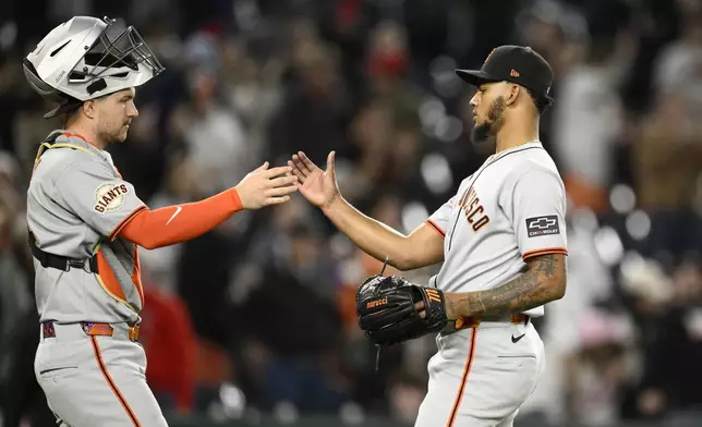 San Francisco Giants relief pitcher Camilo Doval, right, and catcher Patrick Bailey, left, celebrate after a baseball game against the Washington Nationals, Friday, May 23, 2025, in Washington. (AP Photo/Nick Wass)