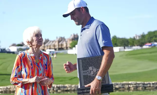 Scottie Scheffler, right, has a moment with Peggy Nelson, left, the wife of the late Byron Nelson, after Scheffler won the CJ Cup Byron Nelson golf tournament in McKinney, Texas, Sunday, May 4, 2025. (AP Photo/LM Otero)