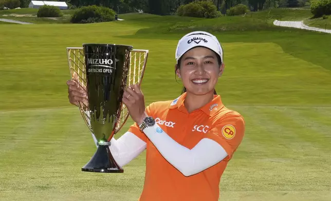 Jeeno Thitikul, of Thailand, poses with her trophy after winning the Mizuho Americas Open LPGA golf tournament, Sunday, May 11, 2025, in Jersey City, N.J. (AP Photo/Seth Wenig)