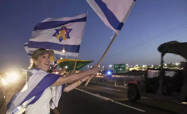 Israelis wave flags as the convoy carrying freed Israeli-American soldier Edan Alexander arrives after his release from Hamas captivity in Gaza to an army base in Reim, near the Gaza border, southern Israel, Monday, May 12, 2025.(AP Photo/Maya Alleruzzo)