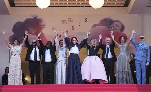Jury president Juliette Binoche, center, poses with jury members Halle Berry, from left, Carlos Reygadas, Dieudo Hamadi, Payal Kapadia, Alba Rohrwacher, Hong Sang-soo, Leila Slimani and Jeremy Strong during the awards ceremony red carpet at the 78th international film festival, Cannes, southern France, Saturday, May 24, 2025. (Photo by Lewis Joly/Invision/AP)