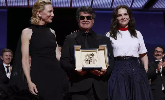 Director Jafar Panahi, centre, accepts the Palme d'Or for the film 'It Was Just an Accident', as he poses with Cate Blanchett, left, and jury president Juliette Binoche during the awards ceremony of the 78th international film festival, Cannes, southern France, Saturday, May 24, 2025. (Photo by Joel C Ryan/Invision/AP)