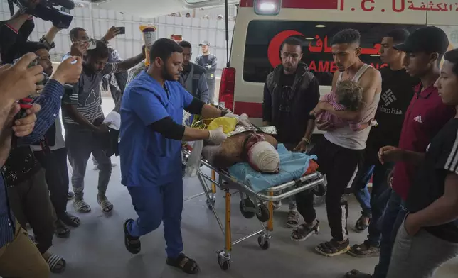 A wounded man and a child are taken into the Nasser hospital after an Israeli army strike hit a house killing at least five members of the Abu Sahloul family, in Khan Younis, in the southern Gaza Strip, Thursday, May 1, 2025. (AP Photo/Abdel Kareem Hana)