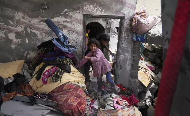 Palestinian children search for belongings in a house damaged by an Israeli army strike that killed at least five people in Khan Younis, in the southern Gaza Strip, Thursday, May 1, 2025. (AP Photo/Abdel Kareem Hana)