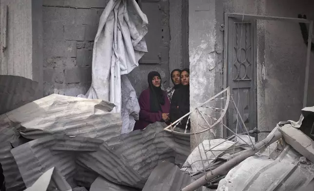 Palestinian women look as residents search the rubble of a house targeted by an Israeli army strike that killed killing at least five members of the Abu Sahloul family in Khan Younis, in the southern Gaza Strip, Thursday, May 1, 2025. (AP Photo/Abdel Kareem Hana)