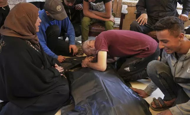 Relatives mourn over the body of Osama Abu Sahloul, who was killed when an Israeli army strike hit a house in Khan Younis, in the southern Gaza Strip, killing at least five members of the Abu Sahloul family, Thursday, May 1, 2025. (AP Photo/Abdel Kareem Hana)