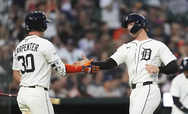 Detroit Tigers' Dillon Dingler, right, celebrates scoring with Kerry Carpenter (30) in the sixth inning during a baseball game against the Boston Red Sox, Monday, May 12, 2025, in Detroit. (AP Photo/Paul Sancya)