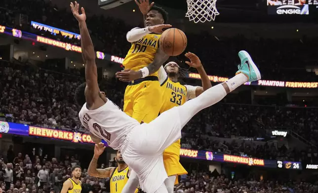 Cleveland Cavaliers forward De'Andre Hunter (12) falls after Indiana Pacers guard Bennedict Mathurin (00) blocked his shot in the second half during Game 1 in the Eastern Conference semifinals of the NBA basketball playoffs Sunday, May 4, 2025, in Cleveland. (AP Photo/Sue Ogrocki)