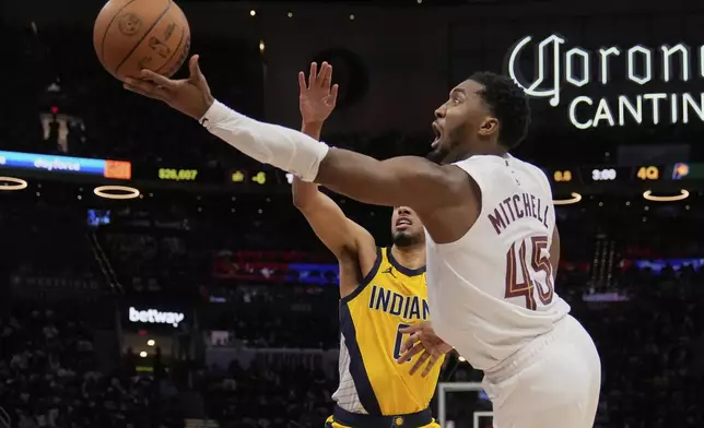 Cleveland Cavaliers guard Donovan Mitchell (45) goes to the basket past Indiana Pacers guard Tyrese Haliburton, left, in the second half during Game 1 in the Eastern Conference semifinals of the NBA basketball playoffs Sunday, May 4, 2025, in Cleveland. (AP Photo/Sue Ogrocki)