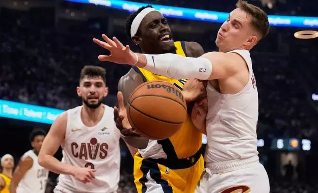 Indiana Pacers forward Pascal Siakam, center, is fouled by Cleveland Cavaliers guard Sam Merrill, right, in the first half during Game 1 in the Eastern Conference semifinals of the NBA basketball playoffs Sunday, May 4, 2025, in Cleveland. (AP Photo/Sue Ogrocki)