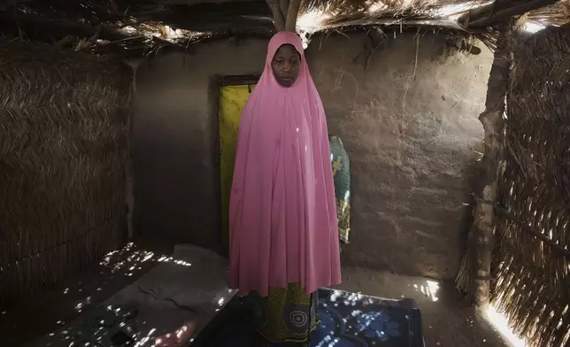 Yagana Bulama, a 40 years old woman is photographed under the dappled light of a thatched shelter in Dikwa, northeastern, Nigeria, Tuesday, April 29, 2025. (AP Photo/Sunday Alamba)