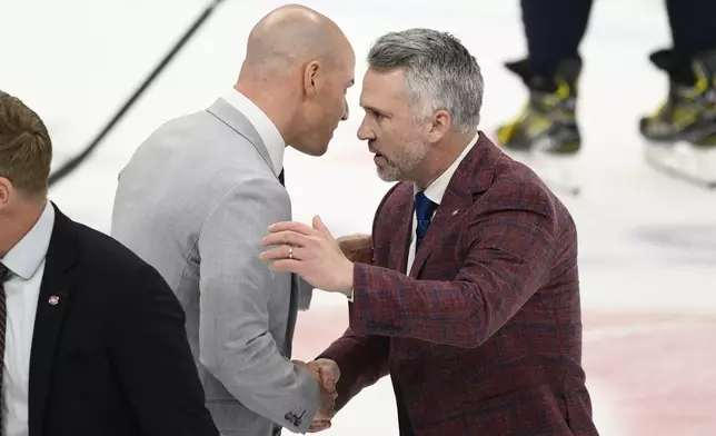 Washington Capitals head coach Spencer Carbery, left, shakes hands with Montreal Canadiens head coach Martin St. Louis, right, after Game 5 of a first-round NHL hockey playoff series Wednesday, April 30, 2025, in Washington. (AP Photo/Nick Wass)