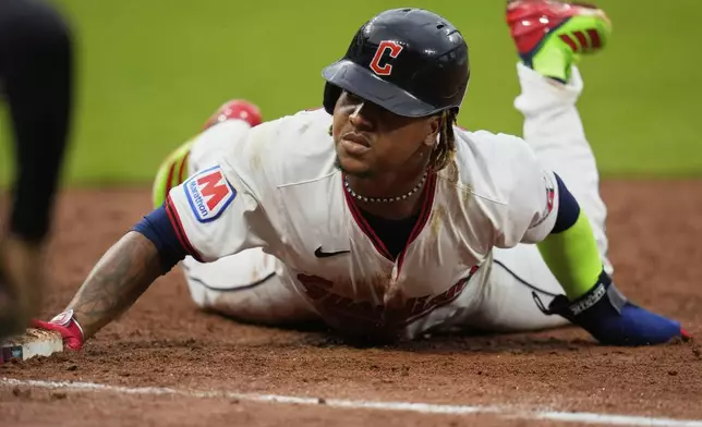Cleveland Guardians' Jose Ramirez dives back into first base on a pickoff-attempt in the 10th inning of a baseball game against the Minnesota Twins in Cleveland, Thursday, May 1, 2025. (AP Photo/Sue Ogrocki)