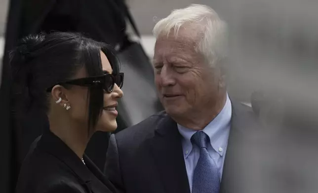 Kim Kardashian, left, speaks with her lawyer Michael Rhodes as she arrives to testify regarding a robbery of millions of dollars in jewels from her Paris hotel room in 2016, in Paris, Tuesday, May 13, 2025. (AP Photo/Aurelien Morissard)