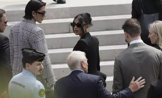 Kim Kardashian, center, accompanied by her mother Kris Jenner, second left, walks up the steps of the palace of justice as she arrives to testify regarding a robbery of millions of dollars in jewels from her Paris hotel room in 2016, in Paris, Tuesday, May 13, 2025. (AP Photo/Aurelien Morissard)