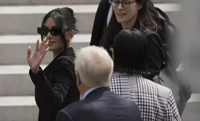 Kim Kardashian, left, walks up the steps of the palace of justice as she arrives to testify regarding a robbery of millions of dollars in jewels from her Paris hotel room in 2016, in Paris, Tuesday, May 13, 2025. (AP Photo/Aurelien Morissard)