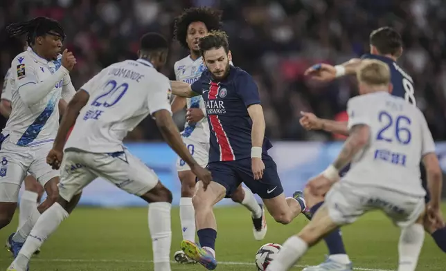 PSG's Khvicha Kvaratskhelia, centre, is surrounded by Auxerre players during the French League One soccer match between Paris Saint-Germain and Auxerre at the Parc des Princes stadium in Paris, Saturday, May 17, 2025. (AP Photo/Christophe Ena)