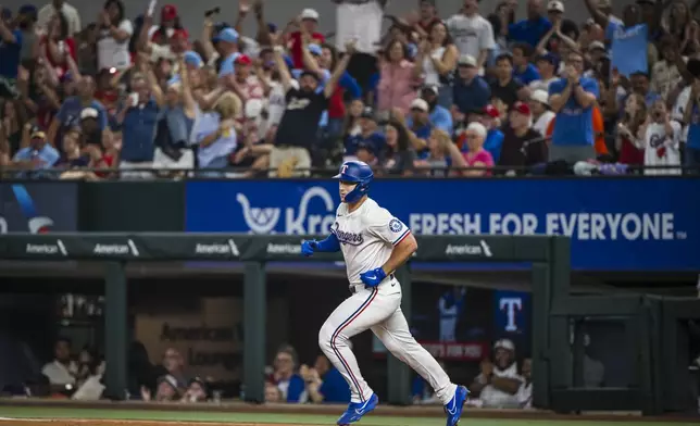 Texas Rangers' Wyatt Langford hits a solo home run during the seventh inning of a baseball game against the Houston Astros, Saturday, May 17, 2025, in Arlington, Texas. (AP Photo/Jessica Tobias)